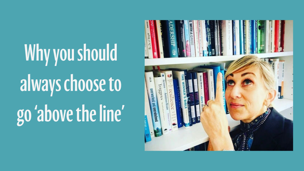 Image of business woman next to bookcase pointing upwards.