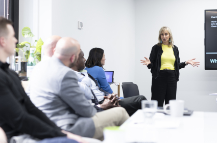 A woman delivering a presentation in a boardroom setting